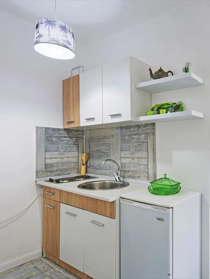 Small kitchen with a sink, built-in cooktop, and refrigerator.