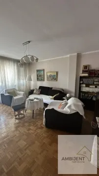 Living room furnished with a sofa set, coffee table, and a bookshelf. - image 7