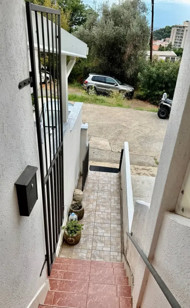 Spoljni ulaz sa stepeništem i stazom koja vodi do objekta.