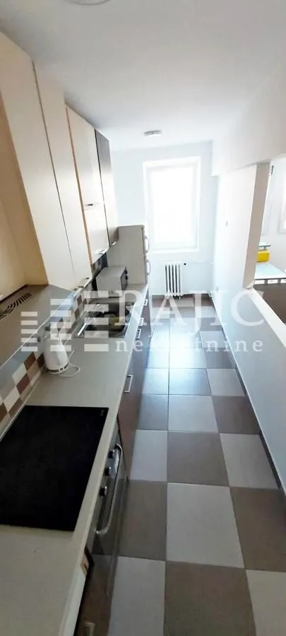 Smaller narrow kitchen with cabinets and floor tiles.