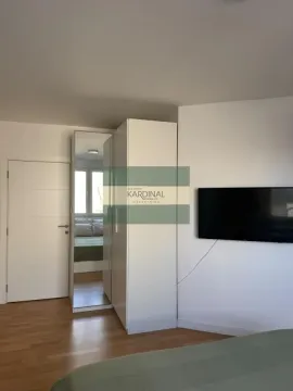 Spavaća soba sa garderoberom, krevetom i zidnim televizorom. - image 8
