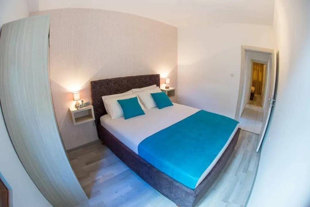 Furnished bedroom with a double bed, bedside tables and a wardrobe.