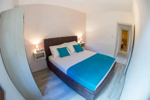 Furnished bedroom with a double bed, bedside tables and a wardrobe. - image 3
