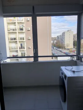Glazed balcony with a washing machine and a view of surrounding buildings. - image 24