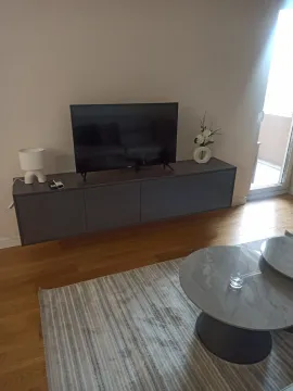 Dio dnevne sobe sa TV komodom i okruglim klub stolovima. - image 8