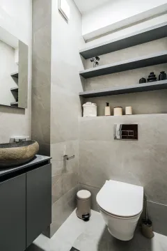 Modern bathroom with a stone basin, toilet and open shelving. - image 13