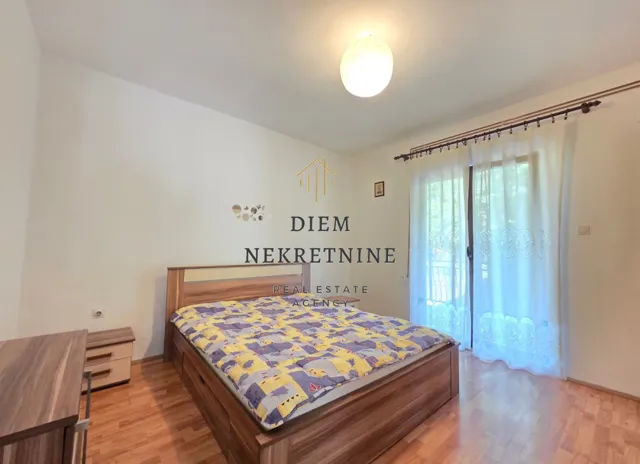 Namještena spavaća soba sa bračnim krevetom i izlazom na terasu.