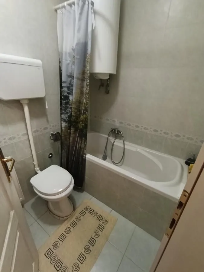 Manje kupatilo sa kadom, toaletom i bojlerom.