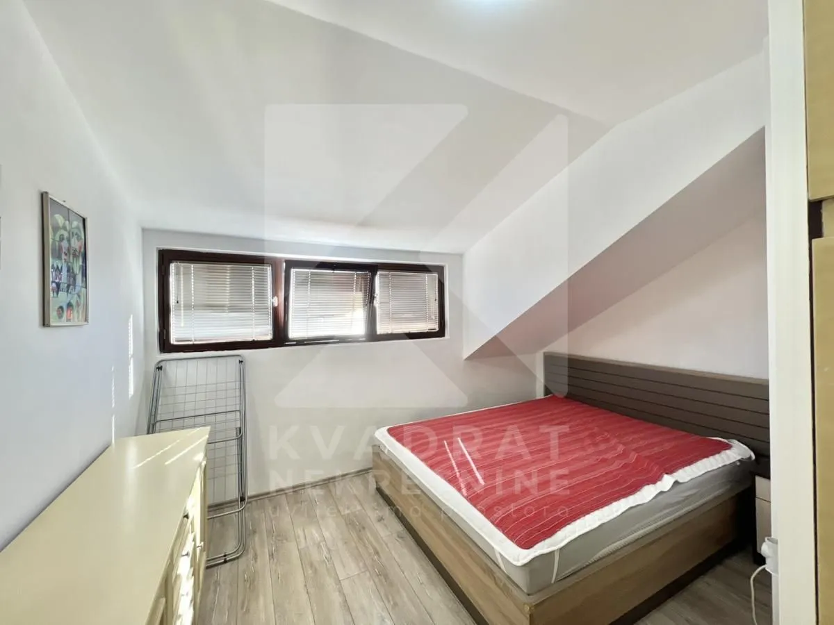 Attic bedroom with a double bed and windows.