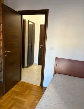 Bedroom with a bed and an open door leading to the hallway. - image 4