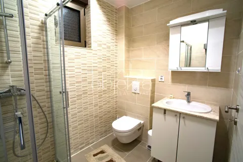 Kupatilo sa tuš kabinom, umivaonikom i ugradnom wc šoljom obloženo keramičkim pločicama. - image 10