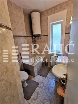 Smaller bathroom with a bathtub, sink, and water heater. - image 12
