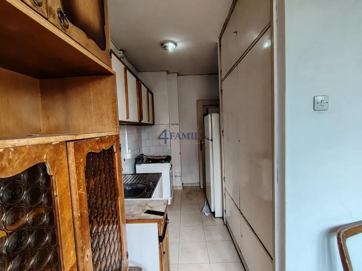 Manja starija kuhinja sa drvenim elementima i belom tehnikom.