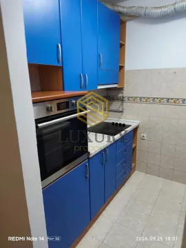 Smaller kitchen with blue cabinets and a built-in oven. - image 5