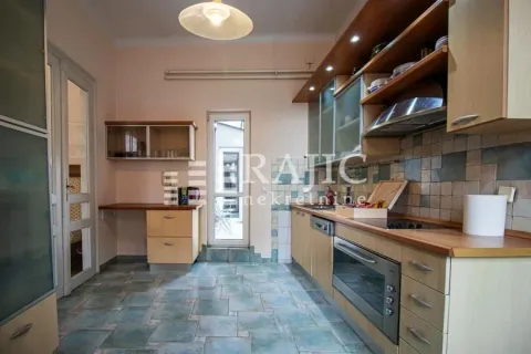 Spacious kitchen with wooden cabinets and ceramic tile flooring. - image 8