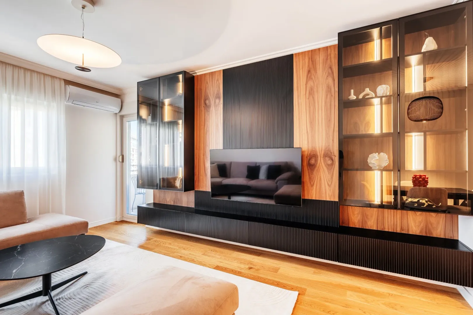 Living room with a modern wall unit, television, and built-in lighting.