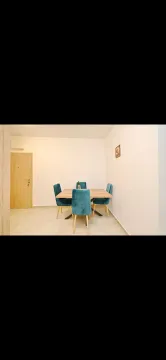 Dining area with a wooden table and blue chairs. - image 6