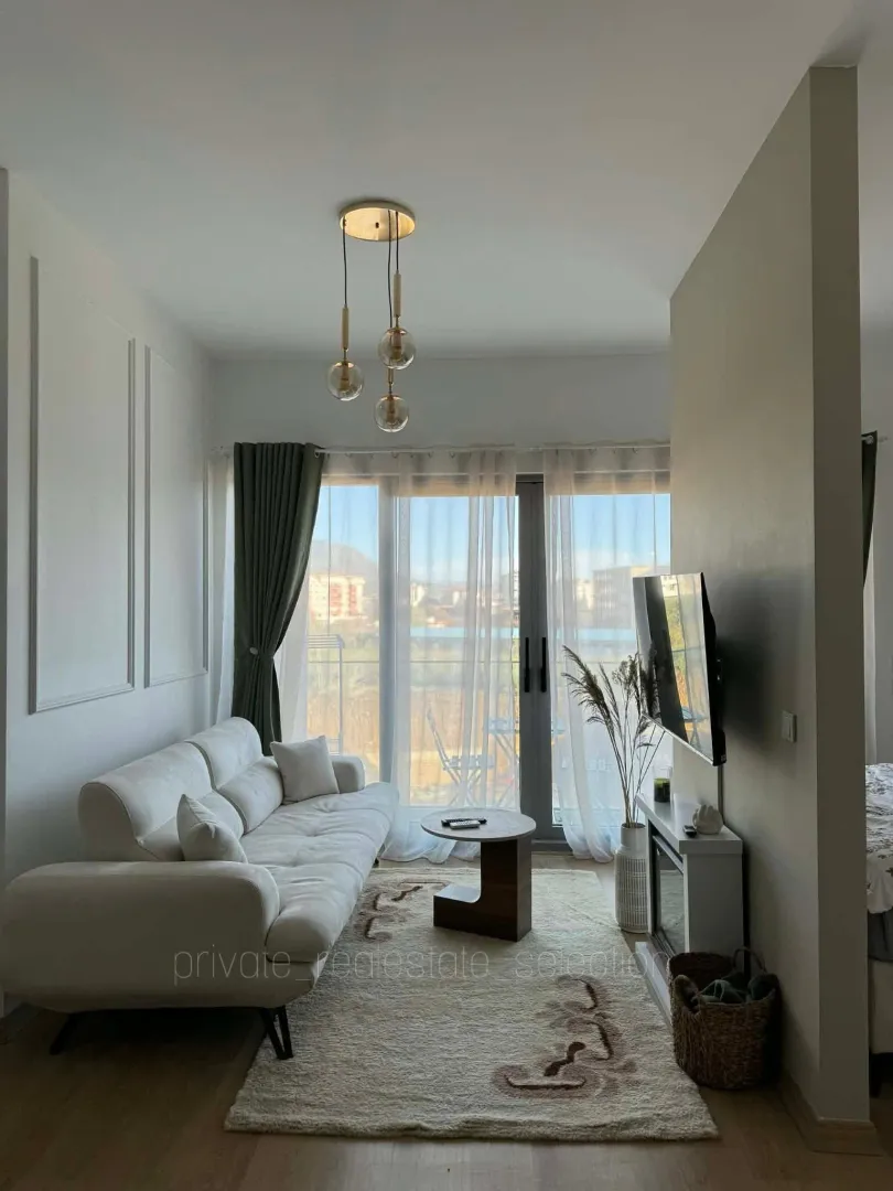 Furnished living room with a light sofa and access to the terrace.