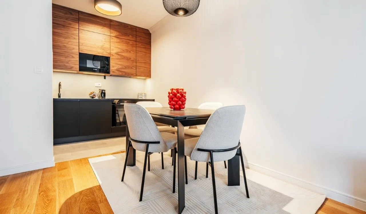 Kitchen with dining area and modern wooden cabinets.