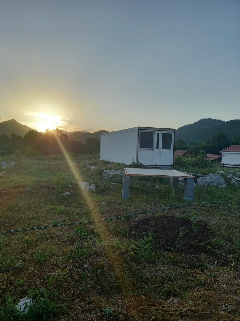Montažni kontejner na placu u prirodi u vrijeme zalaska sunca.