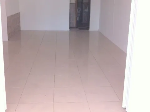 Prazna prostorija sa svijetlim pločicama i pogledom na kupatilo u pozadini. - image 4