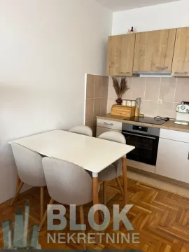 Kitchen with a dining table and wooden elements. - image 3