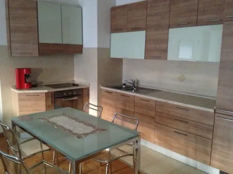 Kitchen with wooden elements and a dining table. - image 5