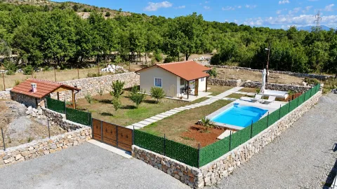 Aerial view of a fenced yard with a house, swimming pool, and auxiliary building. - image 2