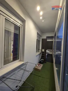 Zastakljeni balkon sa veštačkom travom na podu i sušilicom za veš. - image 24