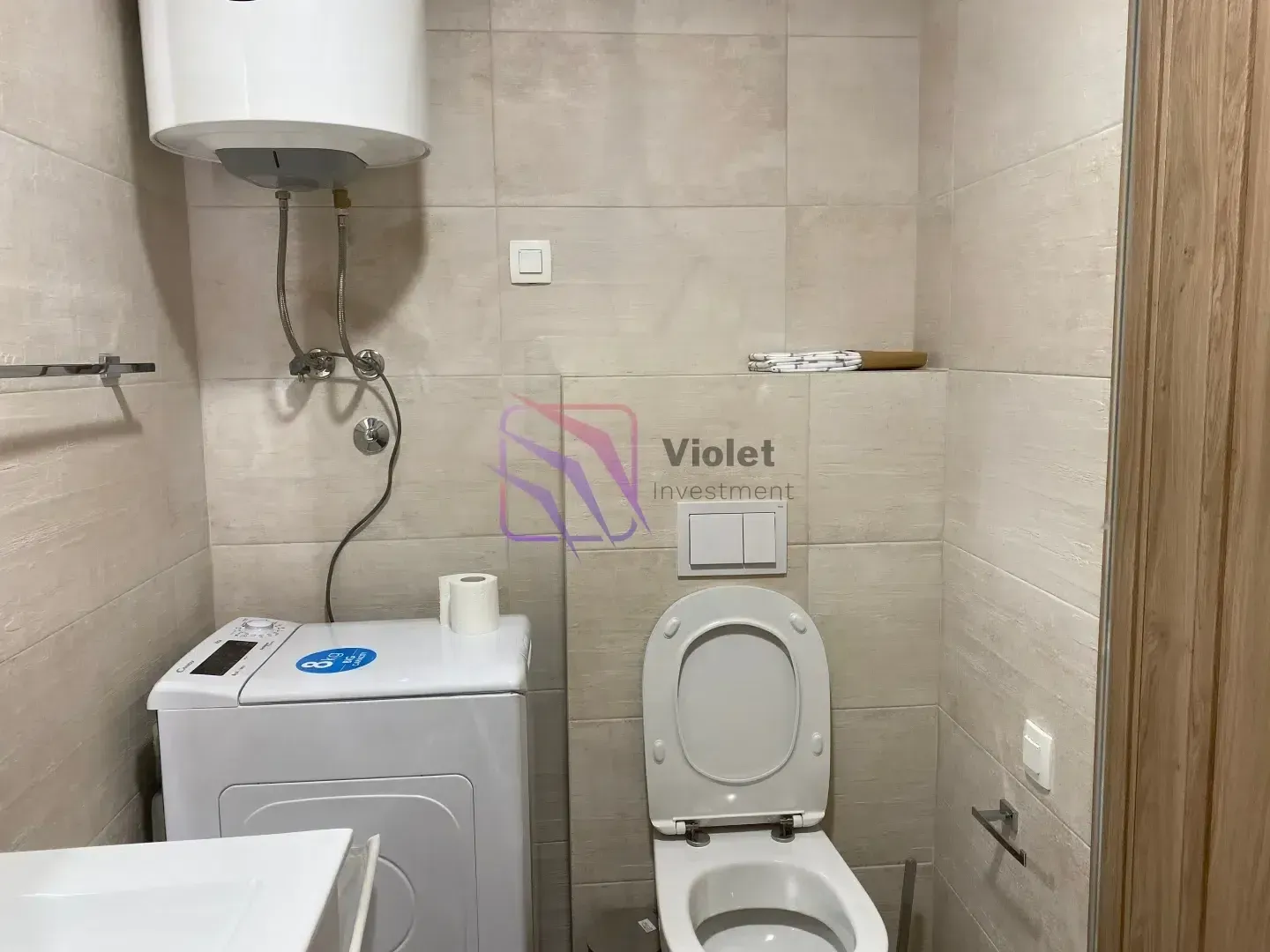 Bathroom equipped with sanitary ware, washing machine and water heater.