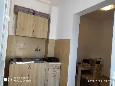 Small kitchen with wooden cabinets and a view of the dining area.