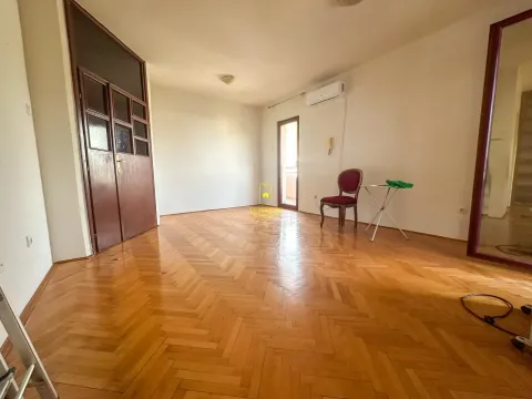 Prazna dnevna soba sa parketom i drvenim vratima. - image 2