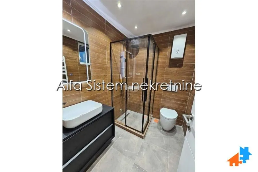 Modernly equipped bathroom with a shower cabin and a washbasin.