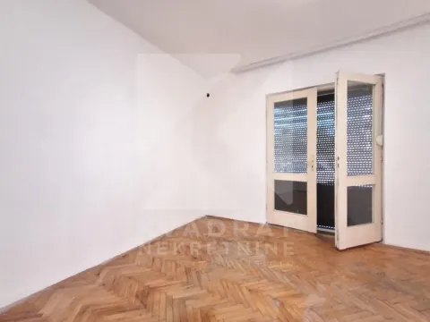 Empty room with hardwood parquet flooring and balcony doors. - image 10