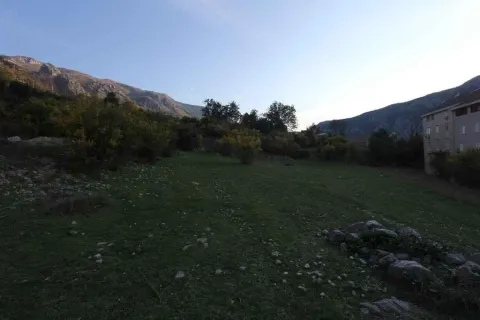 Zeleni plac okružen brdima. - image 7