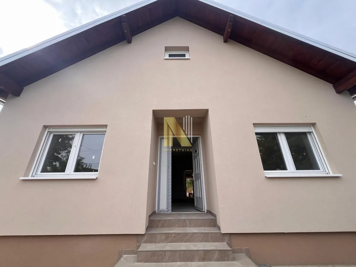Prednji deo kuće sa ulaznim vratima i stepeništem.
