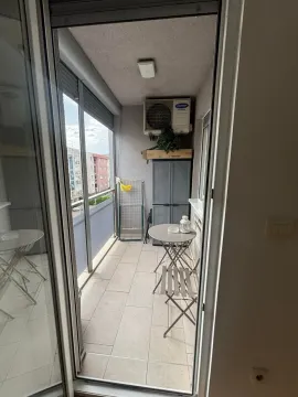 Smaller enclosed balcony with a table, chairs, and a cabinet. - image 5
