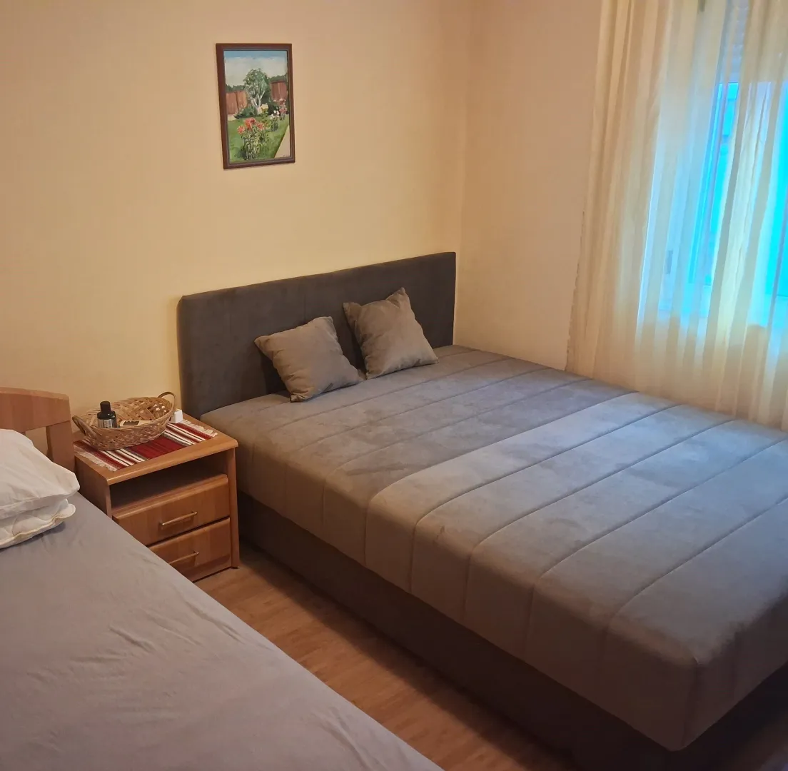 Bedroom with a double bed, nightstand, and a painting on the wall.