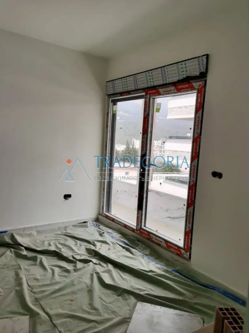 Prazna prostorija u toku renoviranja sa novom balkonskom vratima i zaštitnom folijom na podu.