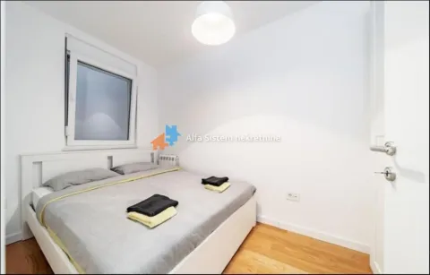 Small bedroom with a double bed, white walls, and a wooden floor. - image 8
