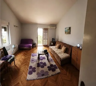 Dnevna soba sa garniturom za sjedenje, drvenim podom i izlazom na terasu. - image 2