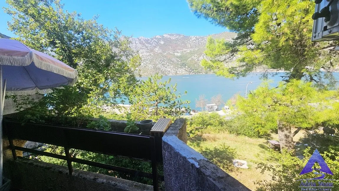 Terasa sa suncobranom i pogledom na more i planine.