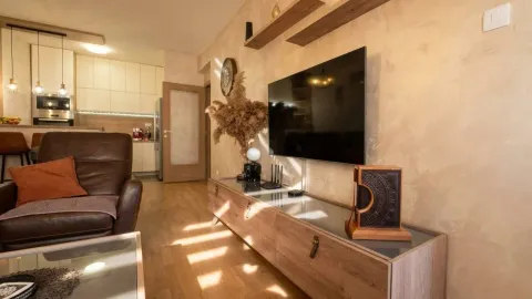 Living room with a TV, wooden console table, and sofa. - image 5