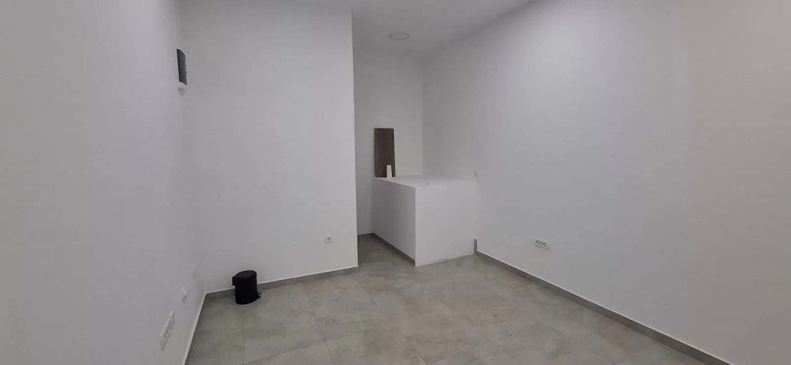 Empty room with white walls and a tiled floor.