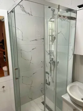 Modernly equipped bathroom with a shower cabin and white ceramic tiles. - image 5