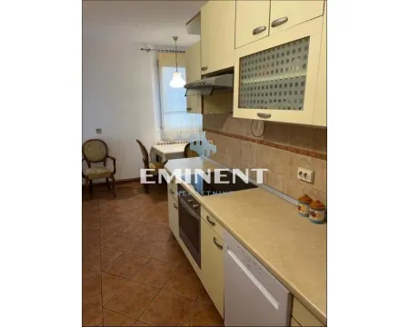 Kitchen with wood-colored units and a dining area in the background. - image 3