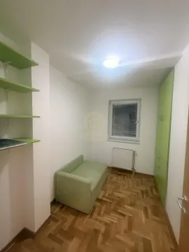Smaller bedroom with a bed, wardrobe, and parquet flooring. - image 9