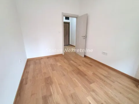 Empty room with wooden flooring and an open door. - image 10