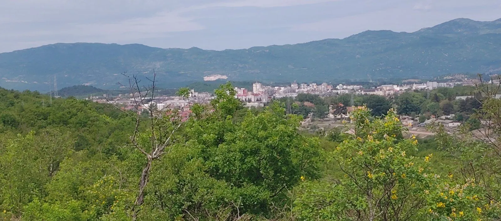 Pogled na grad i planine u daljini.
