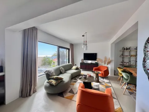 Spacious living room with a sofa, armchairs and a dining area in the background. - image 7